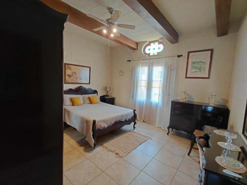 a bedroom with a bed and a ceiling fan at Il- Pellikan Farmhouse in Għajnsielem