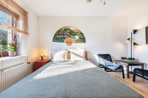 a bedroom with a bed and a chair and a window at Schicke kleine Bude in Neuenkirchen