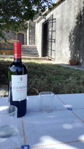 a bottle of wine sitting on a table with glasses at Casa rustica in SantʼAlfio