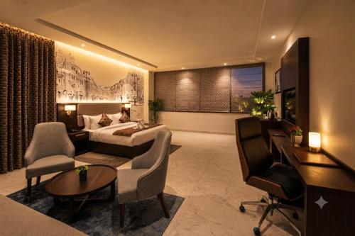 a hotel room with a bed and a desk at Lotus Vista Hotel in Alwar