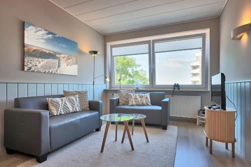 a living room with a couch and a table at Haus Schildt, FeWo 4 in Duhnen