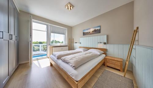 a bedroom with a bed and a large window at Haus Schildt, FeWo 4 in Duhnen