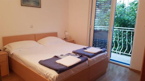 a bedroom with a bed with two towels on it at Apartmani Famelja Jovanovic in Sveti Stefan