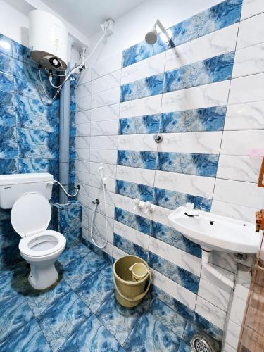 a blue and white bathroom with a toilet and a sink at LS Residency Ac in Thiruchendur