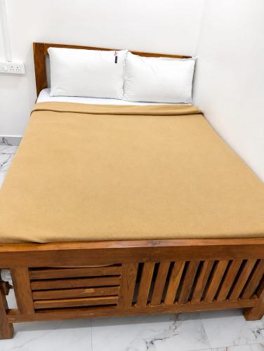 a bed with a wooden frame in a room at LS Residency Ac in Thiruchendur
