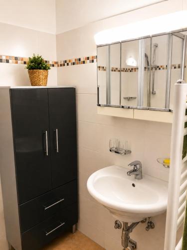 a bathroom with a sink and a black cabinet at Ferienwohnung Evi in Sankt Gilgen