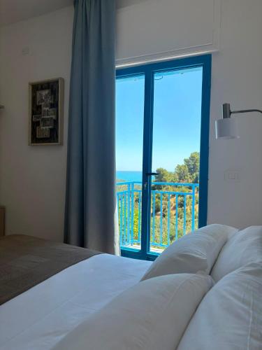 a bedroom with a bed and a view of the ocean at ARTEAMARE in Vignanotica in Mattinata
