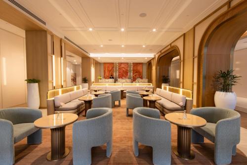 a waiting room with tables and chairs at Amora Hotel Adelaide in Adelaide