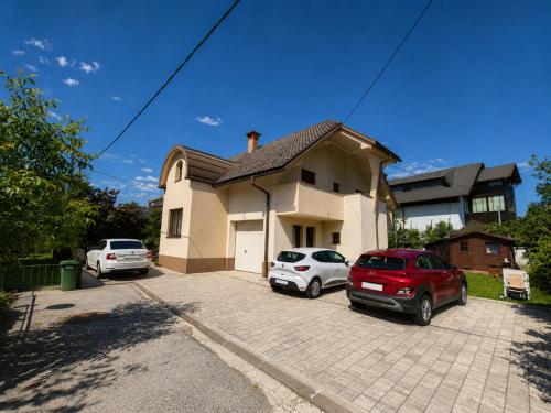 a house with two cars parked in a driveway at Apartment Alee in Lesce
