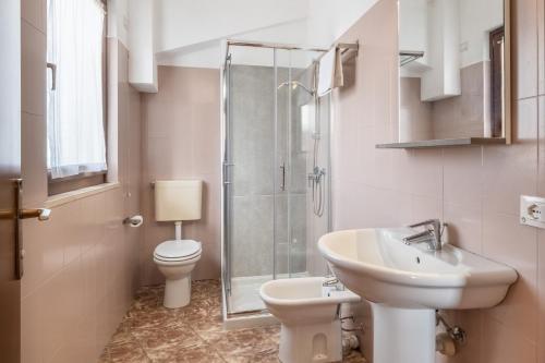 a bathroom with a toilet and a sink and a shower at Hotel La Carica in Pastrengo
