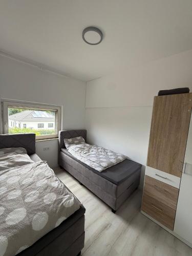 a bedroom with two beds and a window at Deluxe Apartment II in Velpke