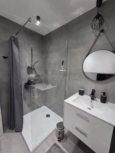 a bathroom with a shower and a sink and a mirror at M&M House in Okuninka