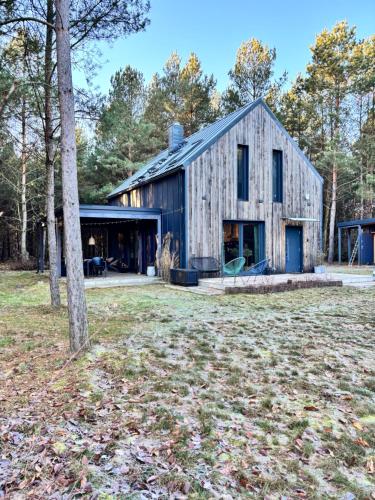 an old barn is shown in a yard at Forest Cabin Modern Barn and Private Woods in Jamielnik