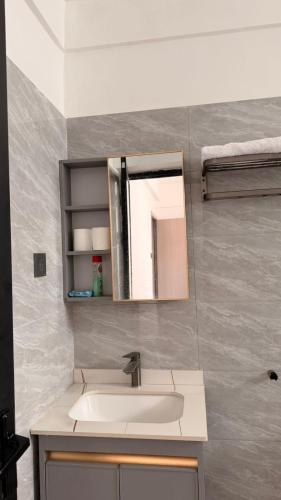 ein Badezimmer mit Waschbecken und Spiegel in der Unterkunft Bloomstays Furnished Apartments Nairobi - Two Bedroom With Sauna Gym & Workspace in Nairobi