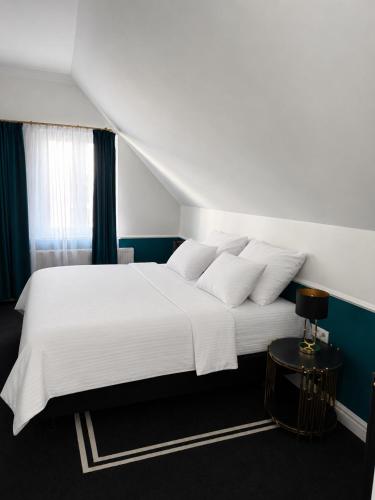 a bedroom with a large white bed with blue walls at Willa Ingeborg in Międzyzdroje