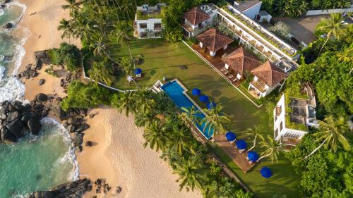 an aerial view of a resort on a beach at Kumu Beach By Teardrop Hotels in Balapitiya