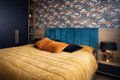 a bedroom with a large bed with a floral wallpaper at Apartmán Alica Tále in Bystrá