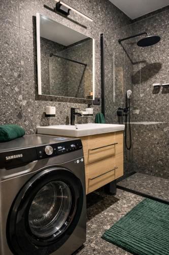 a washing machine in a bathroom with a sink at Apartmán Alica Tále in Bystrá