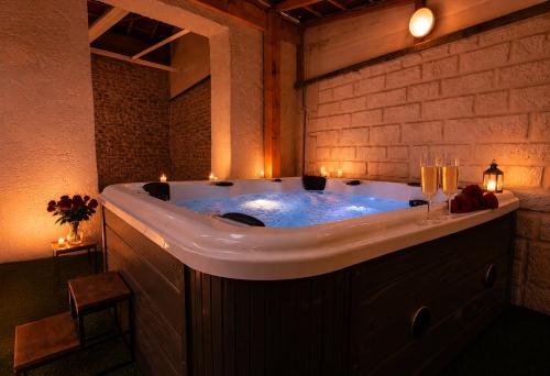 a large bath tub in a room with candles at Les 4 AS de Jaunay, Intime, Jacuzzi in Jaunay-Clan