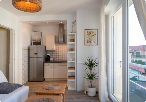 a living room with a refrigerator and a kitchen at Appartement à la Centrale avec vue Océan in Soorts-Hossegor