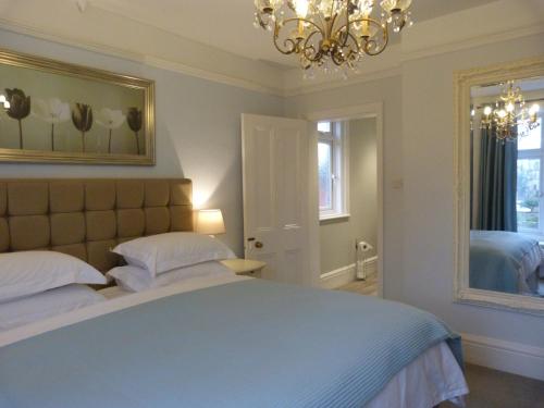 Un dormitorio con una cama grande y una lámpara de araña. en The Old Rectory B&B, en Salisbury