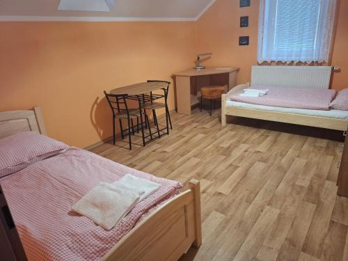 a room with two beds and a table and chairs at Apartmány Prima-Pokoje in Mimoň
