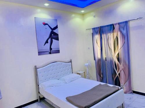a bedroom with a bed and a picture of a woman at Kër-Mame Tawfekh in Thiès