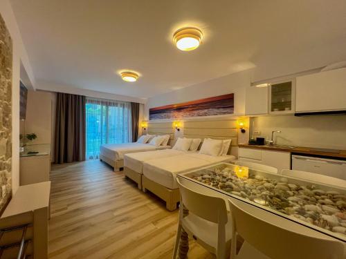 a hotel room with two beds and a kitchen at Valentinos House in Parga