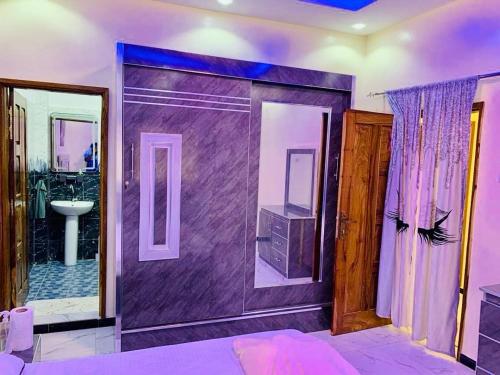 a purple bathroom with a sink and a shower at Kër-Mame Tawfekh in Thiès