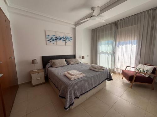a bedroom with a bed and a chair and a window at Dumar Puerto Rey in Vera