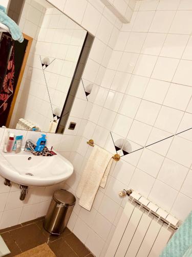 a white bathroom with a sink and a mirror at Private room with shared bathroom in Clavier