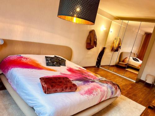 a bedroom with a bed with a colorful blanket and a mirror at Private room with king size bed - shared bathroom in Clavier