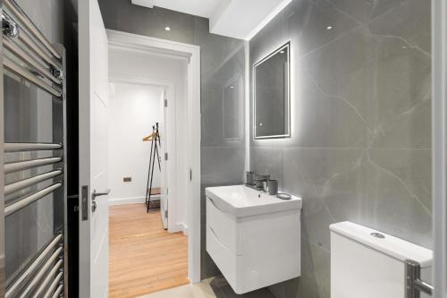 a bathroom with a white toilet and a sink at Bright 2BR Flat Close to Shops in Beckenham in Beckenham