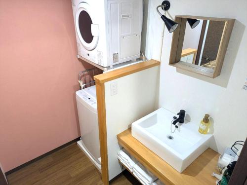 a bathroom with a sink and a washing machine at Hotel Miyakojima in Miyako-jima