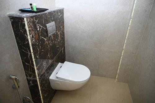 a bathroom with a white toilet in a stall at Hotel Siya Grand in Tirupati