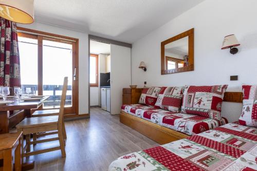 a room with a bed and a couch and a table at Résidence Odalys Le Hameau du Mottaret in Méribel