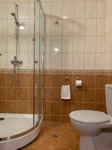 a bathroom with a toilet and a glass shower at Kaliakria Pearl Resort in Topola