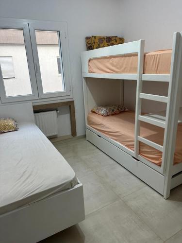 a bedroom with two bunk beds and a window at Zaineb in Hammamet Sud