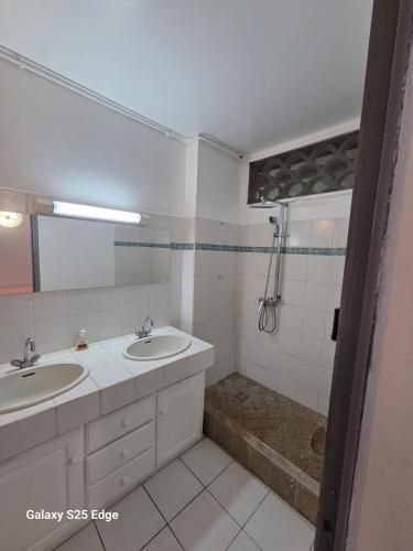 a white bathroom with two sinks and a shower at Studio ALIZÉS in Le Moule