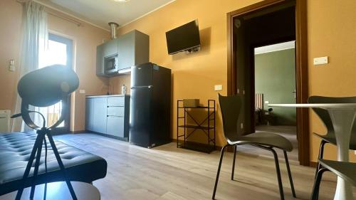 a kitchen with a black refrigerator and a table and chairs at Nextop Homes in Tortona
