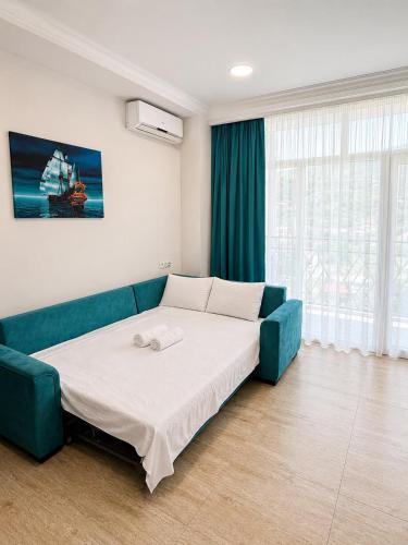 a bedroom with a bed and a blue couch at All seasons in Gonio beach in Gonio