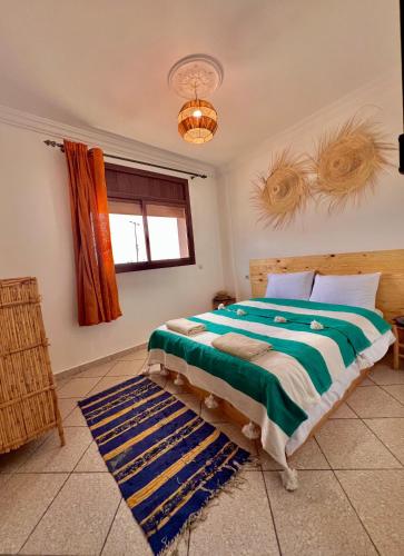 a bedroom with a bed and a window at Amzil Surf House in Aourir