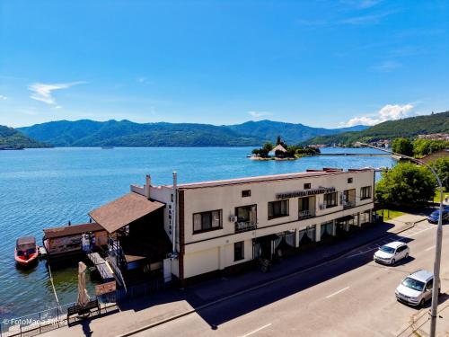 a building on the side of a body of water at Pensiunea Damiro in Orşova