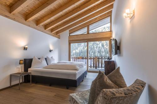 a bedroom with a bed and a large window at Chasa Teja by MEIN SAMNAUN - MOUNTAIN HOMES in Samnaun
