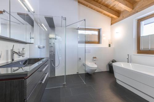 a bathroom with a tub and a sink and a toilet at Chasa Teja by MEIN SAMNAUN - MOUNTAIN HOMES in Samnaun