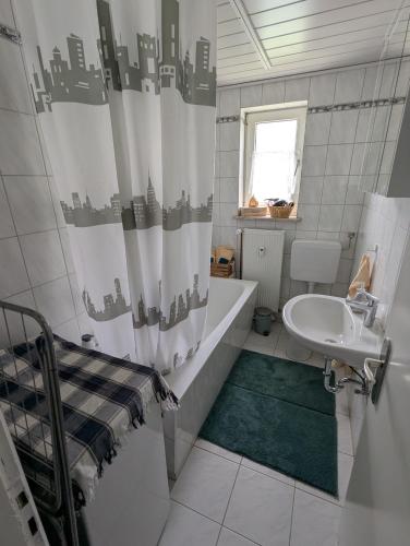 a bathroom with a sink and a shower curtain at Holm in Melsungen