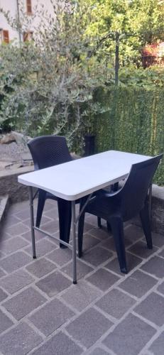 a white table and two chairs on a patio at Casa Olivia in Margno