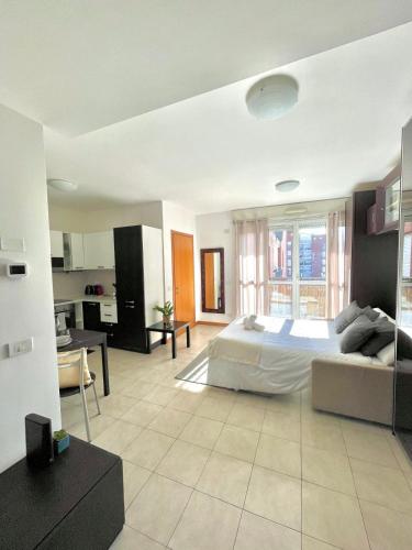 a large bedroom with a bed and a kitchen at Monolocale moderno - Colazione Inclusa in Vimodrone