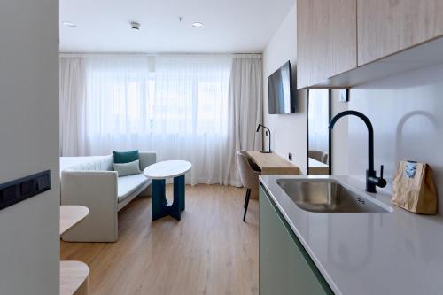 a kitchen and living room with a couch and a table at Flipco Retiro in Madrid