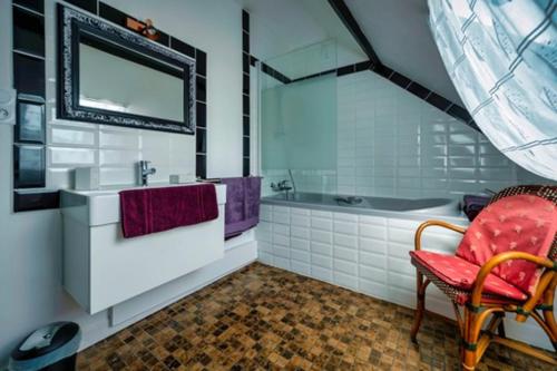 a bathroom with a sink and a tub and a chair at Chambres d'hôtes Ecole Buissonnière en Dordogne in Le Buisson de Cadouin